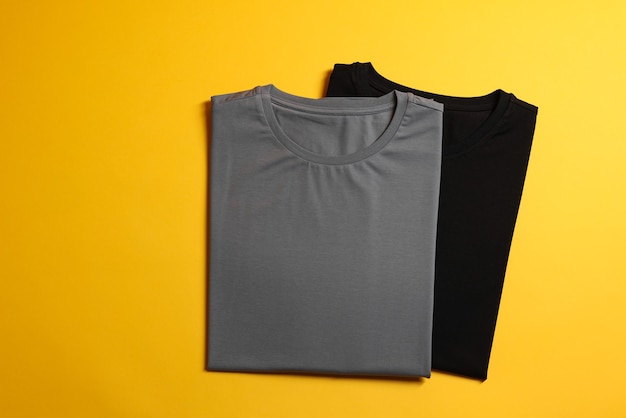 Diferentes camisetas en blanco en fondo amarillo vista superior Maqueta para el diseño