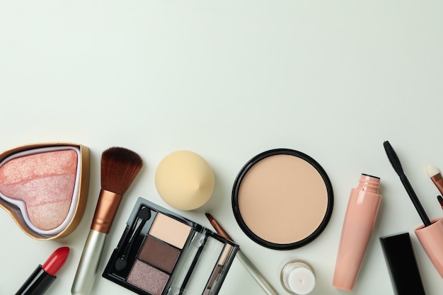 Diferentes cosméticos de maquiagem em fundo branco, espaço para texto