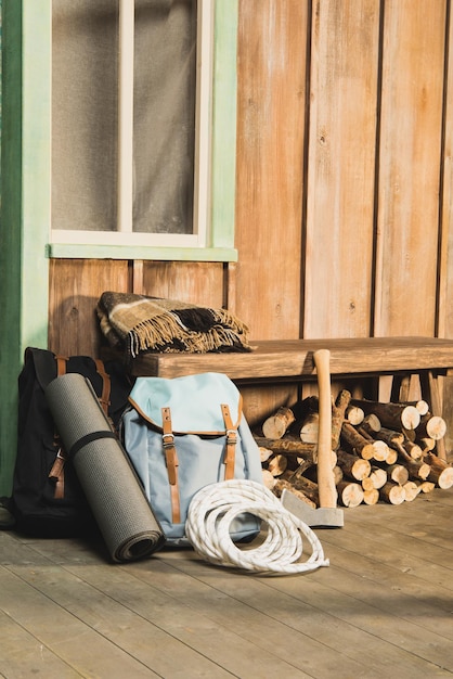 Diferentes equipamentos de trekking no banco perto da casa de madeira esperando pelo viajante