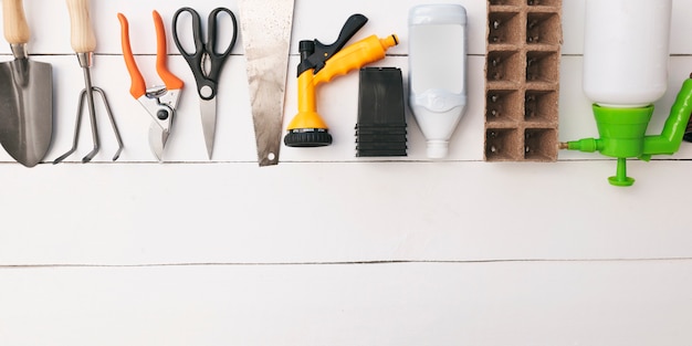 Foto diferentes equipos de jardinería en mesa de madera