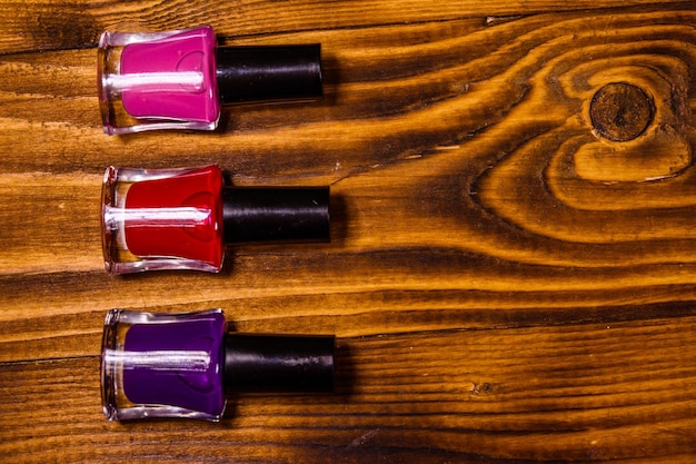 Diferentes esmaltes de uñas en una mesa de madera Vista superior