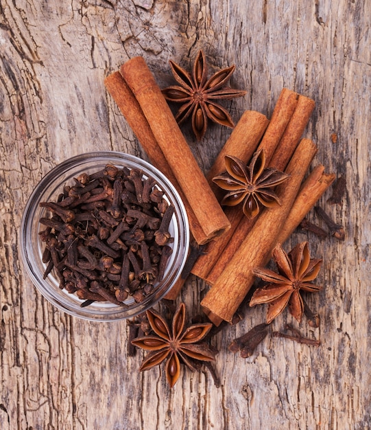 Diferentes especias, canela, anís en mesa de madera vieja