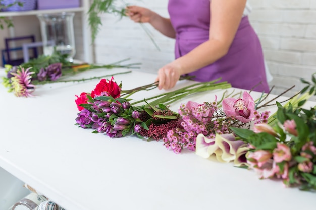 Diferentes flores sobre la mesa blanca en florería