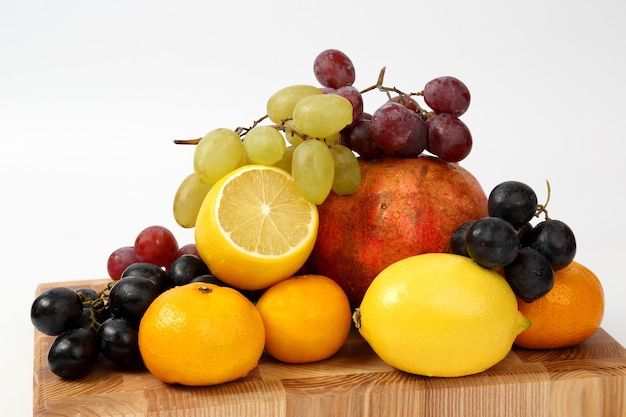 Diferentes frutas en una tabla de madera aislada