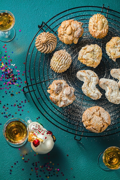 Diferentes galletas de almendras caseras italianas clásicas con café expreso y vasos de licor dulce sobre la mesa, decoración navideña