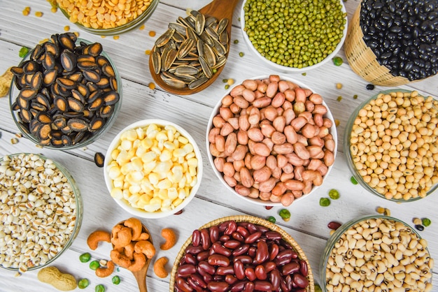 Diferentes grãos integrais na tigela e legumes sementes lentilhas e nozes lanche colorido fundo vista superior - vários feijões de colagem misturam agricultura de ervilhas de alimentos saudáveis naturais para cozinhar ingredientes