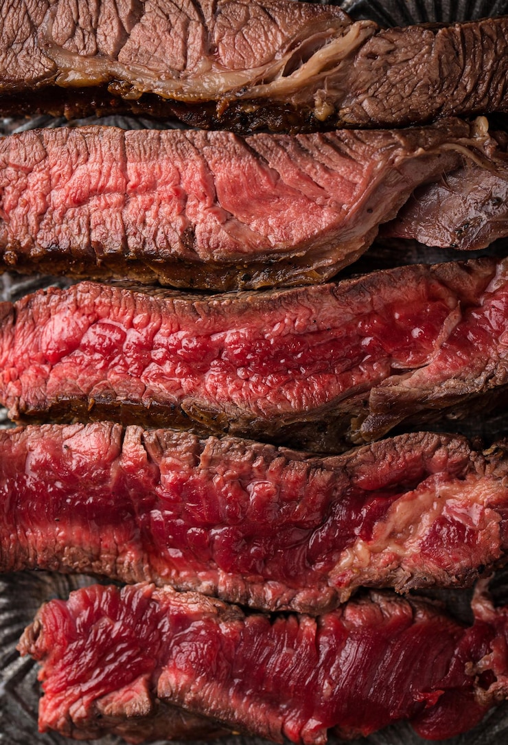 Foto diferentes graus de assado de bife bife com sangue bife assado médio a alto em uma tábua de madeira