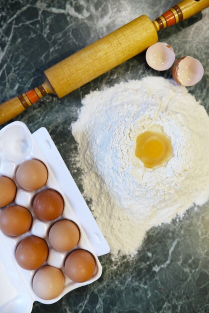 Diferentes ingredientes para preparar productos de harina en la mesa de la cocina.