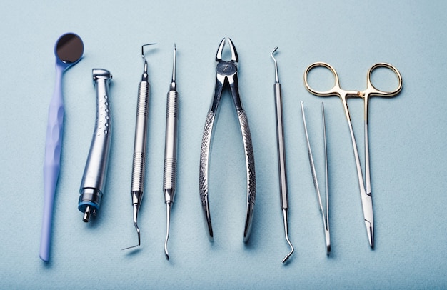 Foto diferentes instrumentos dentales de acero sobre fondo azul claro