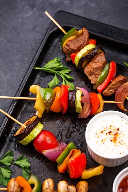 Diferentes kebabs grelhados com carne, cogumelos, salsichas e vegetais no espeto