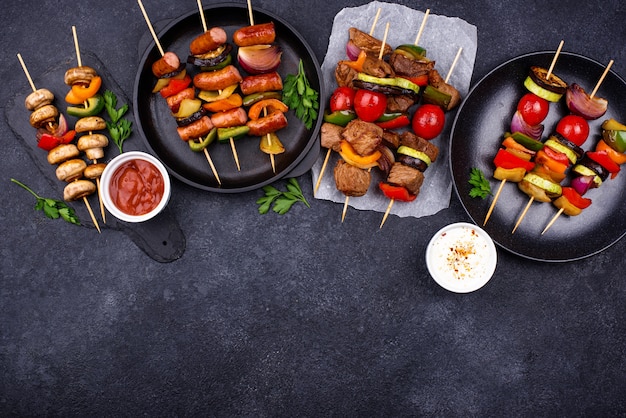 Diferentes kebabs a la plancha con carne, champiñones, salchichas y verduras en brochetas