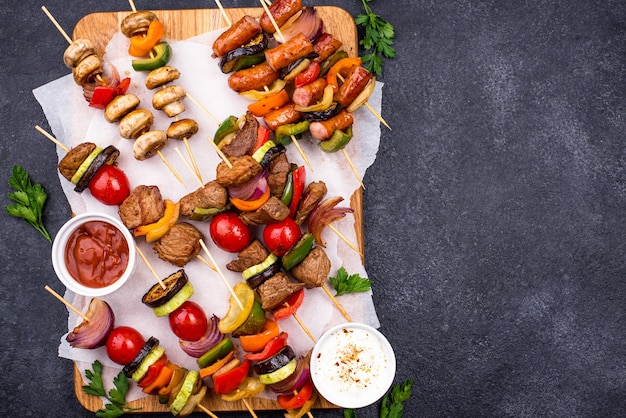 Diferentes kebabs a la plancha con carne, champiñones, salchichas y verduras en brochetas