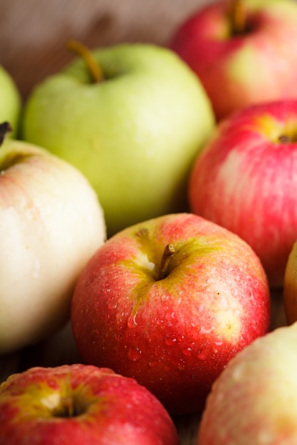 Diferentes manzanas en la mesa de madera en el jardín