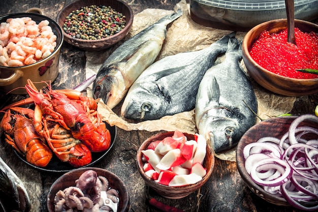 Diferentes mariscos con gambas y caviar rojo. Sobre un fondo de madera.