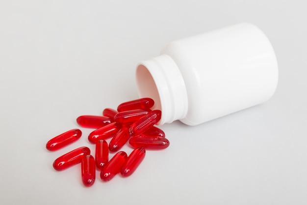 Diferentes medicamentos e pílulas de suplementos de saúde derramados de uma garrafa de medicamento, cuidados de saúde e vista superior médica em fundo colorido