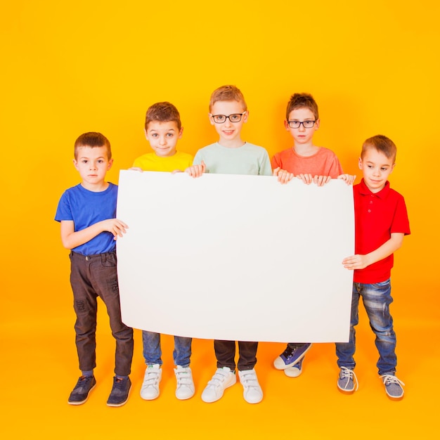 Foto los diferentes niños pequeños sostienen un gran libro blanco.