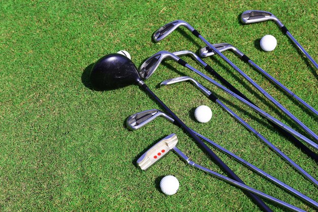 Diferentes palos de golf y pelotas en campo de golf