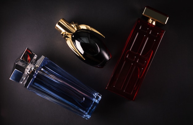 Diferentes perfumes de mujer sobre una superficie oscura.