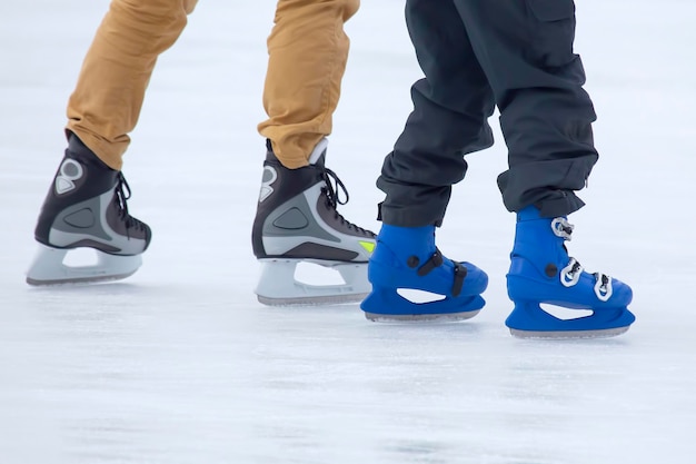 Diferentes personas están patinando activamente en una pista de hielo. Pasatiempos y deportes. Vacaciones y actividades invernales.