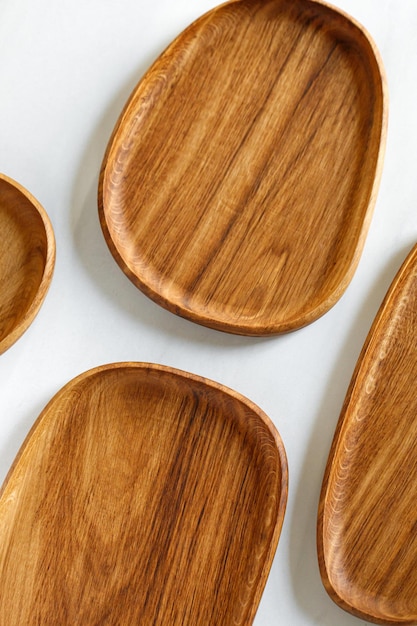 Diferentes platos de madera de roble tableros bandejas Platos de madera vacíos en la mesa blanca de la cocina Utensilios de cocina