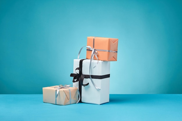 Diferentes tamanhos coloridos de caixas de presente de papel listrado e simples amarradas com fitas e arcos em um azul sur