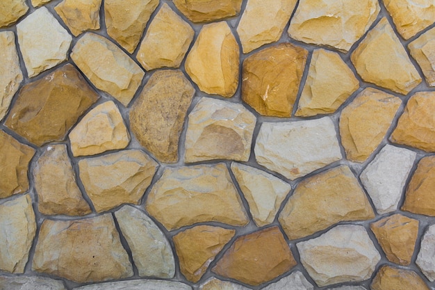 Diferentes tamaños de piedras de arena. Patrón de la pared de piedra