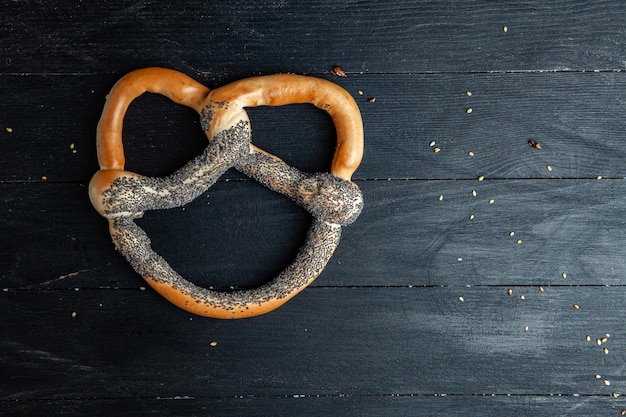 Foto diferentes tipos de bagels horneados con semillas sobre un fondo negro