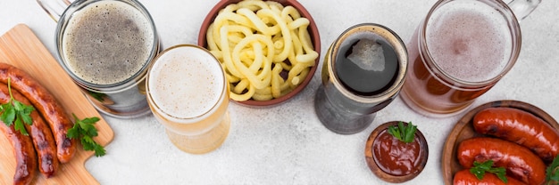 Foto diferentes tipos de cerveza y comida vista superior.
