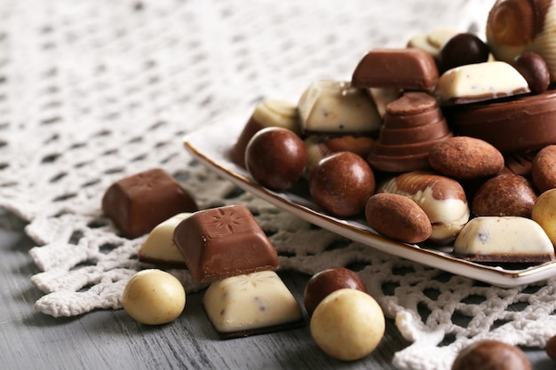 Diferentes tipos de chocolates en plato sobre mesa de madera