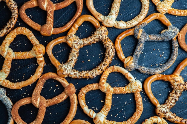 Diferentes tipos de bagels assados com sementes em um fundo preto