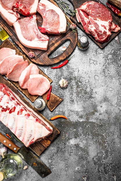 Diferentes tipos de carne de porco crua e bovina com especiarias e ervas.