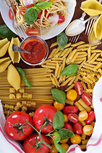 Foto diferentes tipos de massas com tomates e manjericão