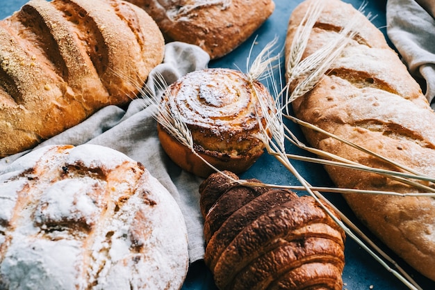 Diferentes tipos de pão fresco e padaria na mesa.