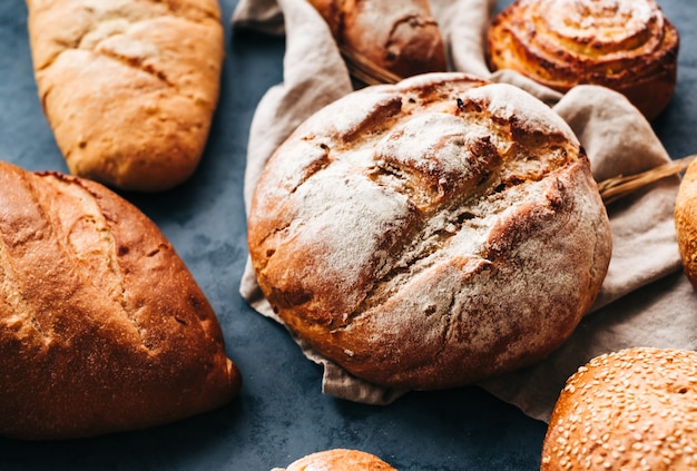 Diferentes tipos de pão fresco e padaria na mesa.