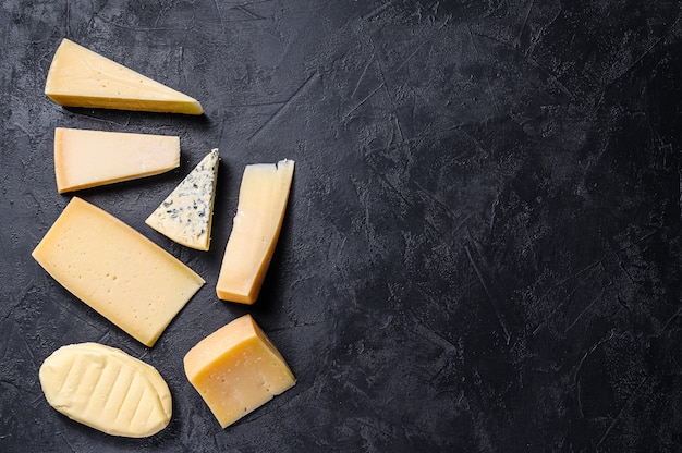 Diferentes tipos de queijo delicioso. fundo preto. vista do topo. espaço para texto