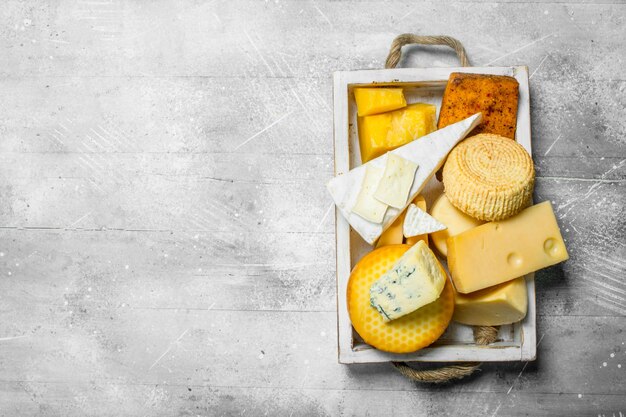 Diferentes tipos de queijo na bandeja de madeira
