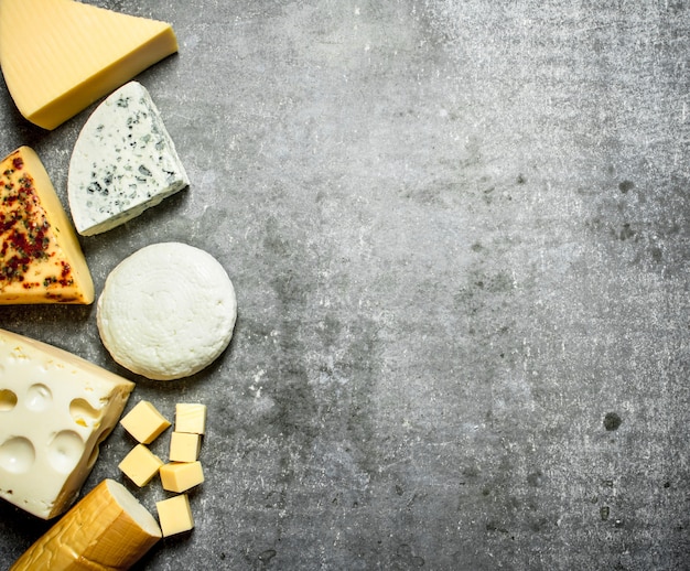 Diferentes tipos de queijo. Na mesa de pedra.