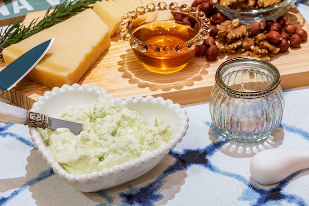 Diferentes tipos de queijos, vinhos, baguetes, frutas e petiscos à mesa para degustação e cenário de férias.