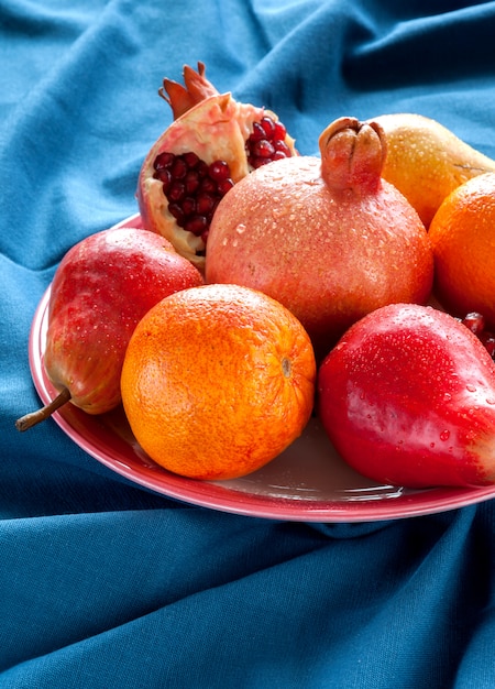 Diferentes tipos de frutas en una mesa de madera. Peras, granadas, naranjas, toronjas.