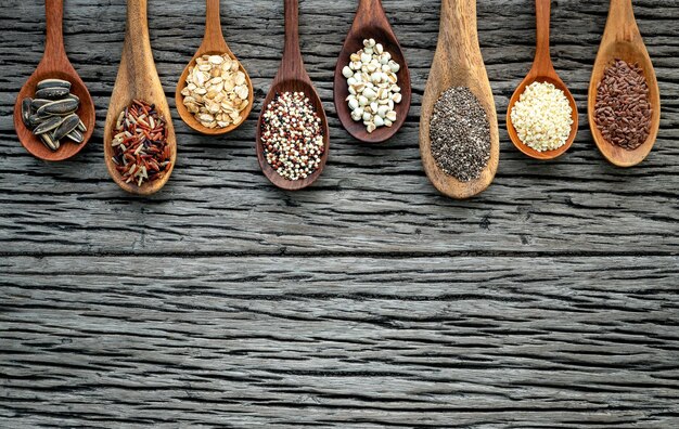 Foto diferentes tipos de granos y cereales sobre un fondo de madera en mal estado