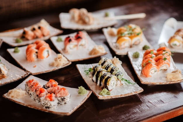 Diferentes tipos de juegos de sushi en platos de arcilla sobre una mesa en un restaurante