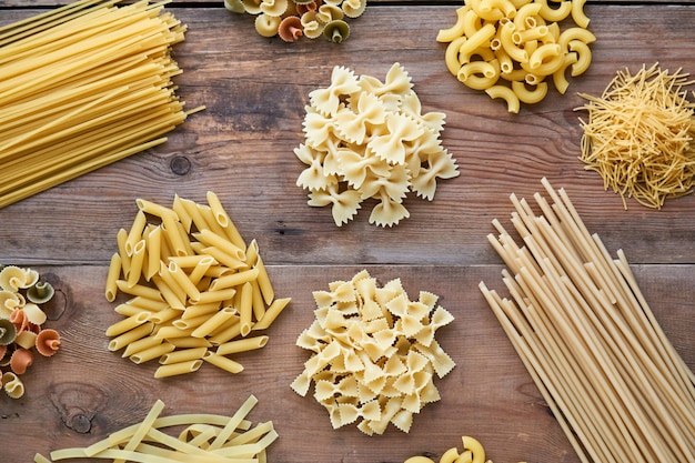 Diferentes tipos de pasta cruda sobre fondo de madera vieja