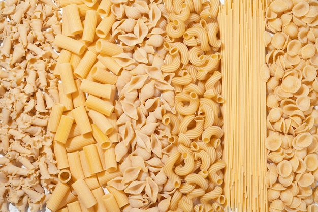 Diferentes tipos de pasta cruda sobre fondo textil