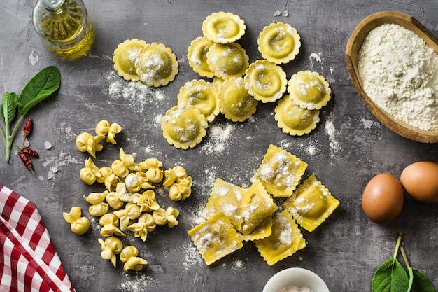 Diferentes tipos de raviolis italianos crudos frescos en la mesa con ingredientes de cocina cocina casera