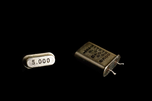 Foto diferentes tipos de resonadores de cuarzo. aislado sobre fondo negro. componentes electrónicos.