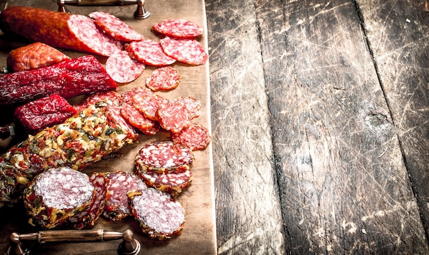 Diferentes tipos de salami en las tablas sobre un fondo de madera