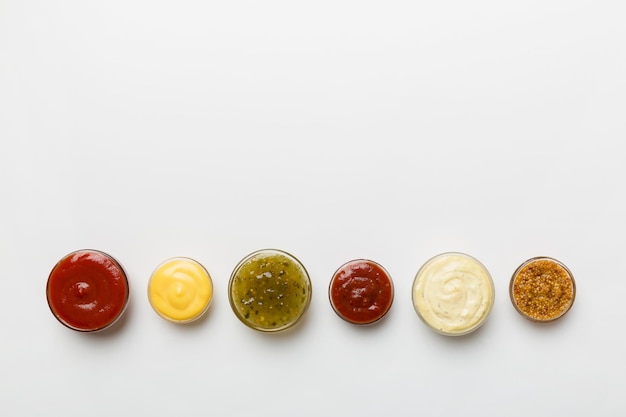 Diferentes tipos de salsas en tazones en un tablero de colores Vista superior varias salsas espacio de copia