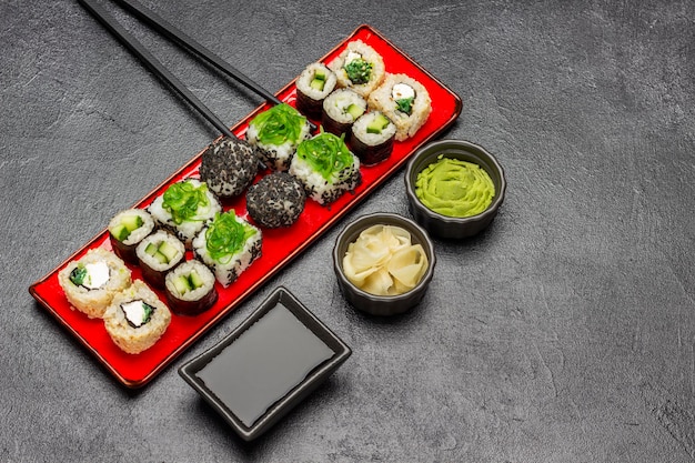 Diferentes tipos de sushi en un plato rojo.