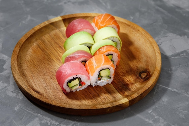 Diferentes tipos de sushi y rollos deliciosos y jugosos en una tabla de madera