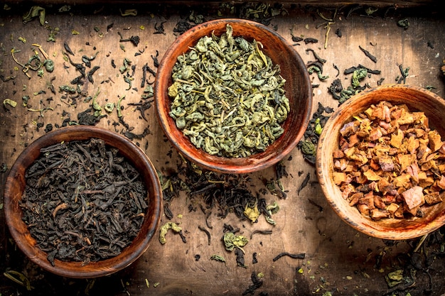 Diferentes tipos de té aromático en tazones. Sobre un fondo rústico.